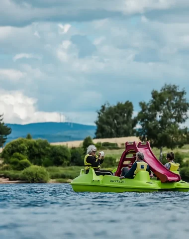 Family in a pedal boat on Lake Naussac
